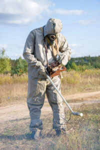 A person measures the radiation levels in a location to assess its radiation exposure.