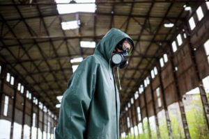 A man in a protective mask and protective clothing explores the danger zone.