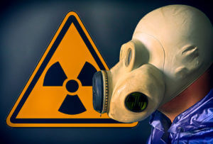 Man in the gas mask near the radiation sign.